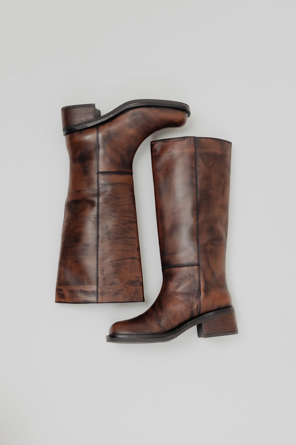 Pair of brown knee-high boots on a light gray background