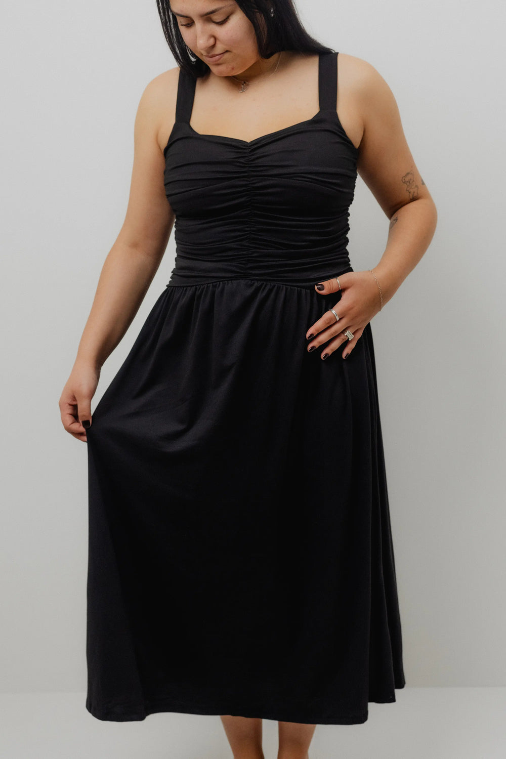 Woman wearing a black dress against a white background