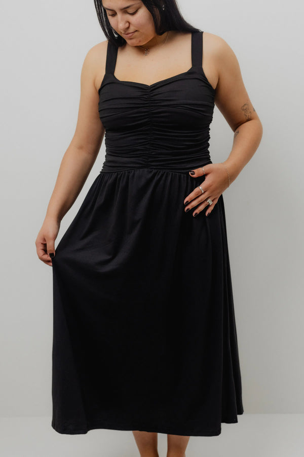 Woman wearing a black dress against a plain background