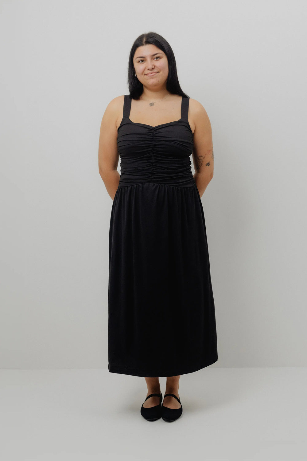 Woman wearing a black dress against a white background