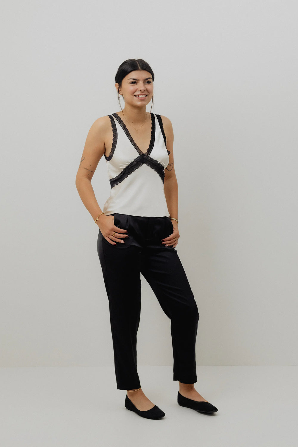 Person wearing black pants on a plain background