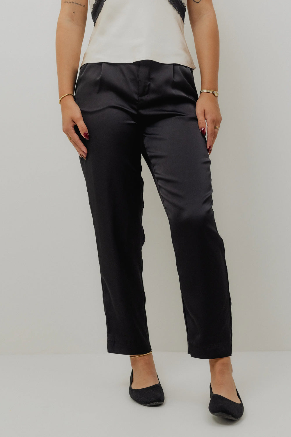 Person wearing black pants on a plain background