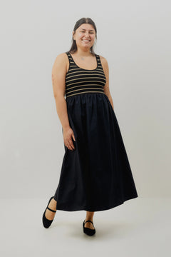 Woman wearing a black dress with a striped top on a white background