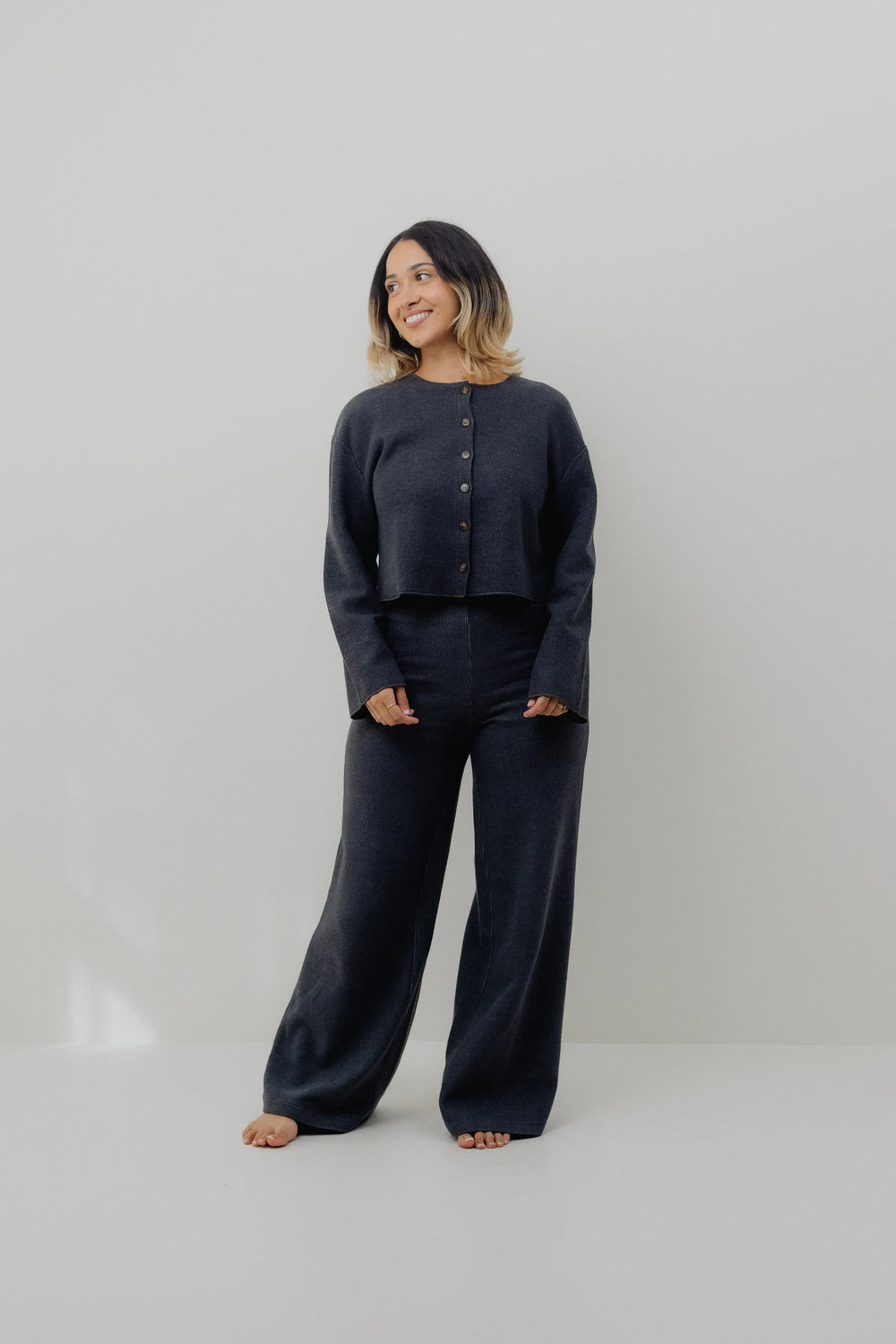 Woman wearing a dark blue outfit on a plain background