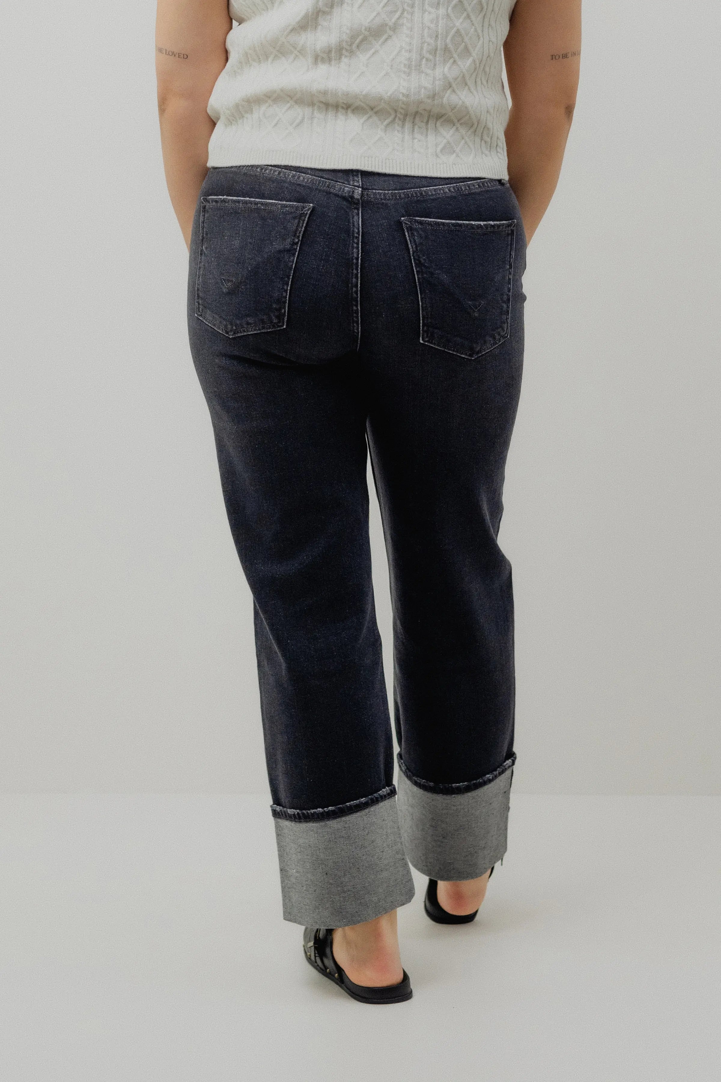 Person wearing dark blue jeans with a white background