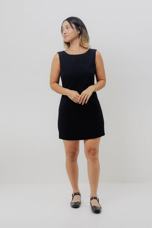 Woman wearing a black sleeveless dress on a white background