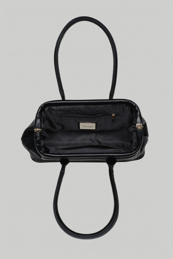 Black handbag with gold accents on a light gray background