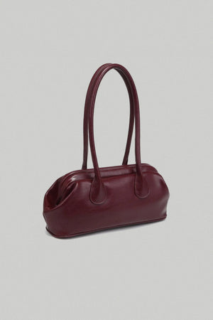 Burgundy handbag on a light gray background