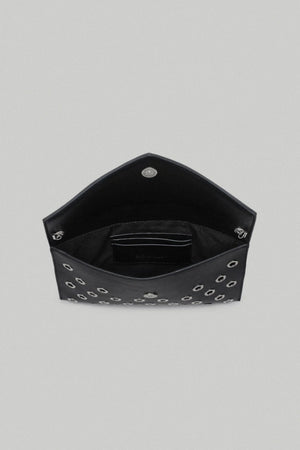 Black hexagonal clutch bag with studded details on a gray background