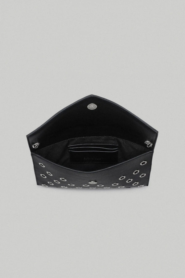 Black hexagonal clutch bag with studded details on a gray background